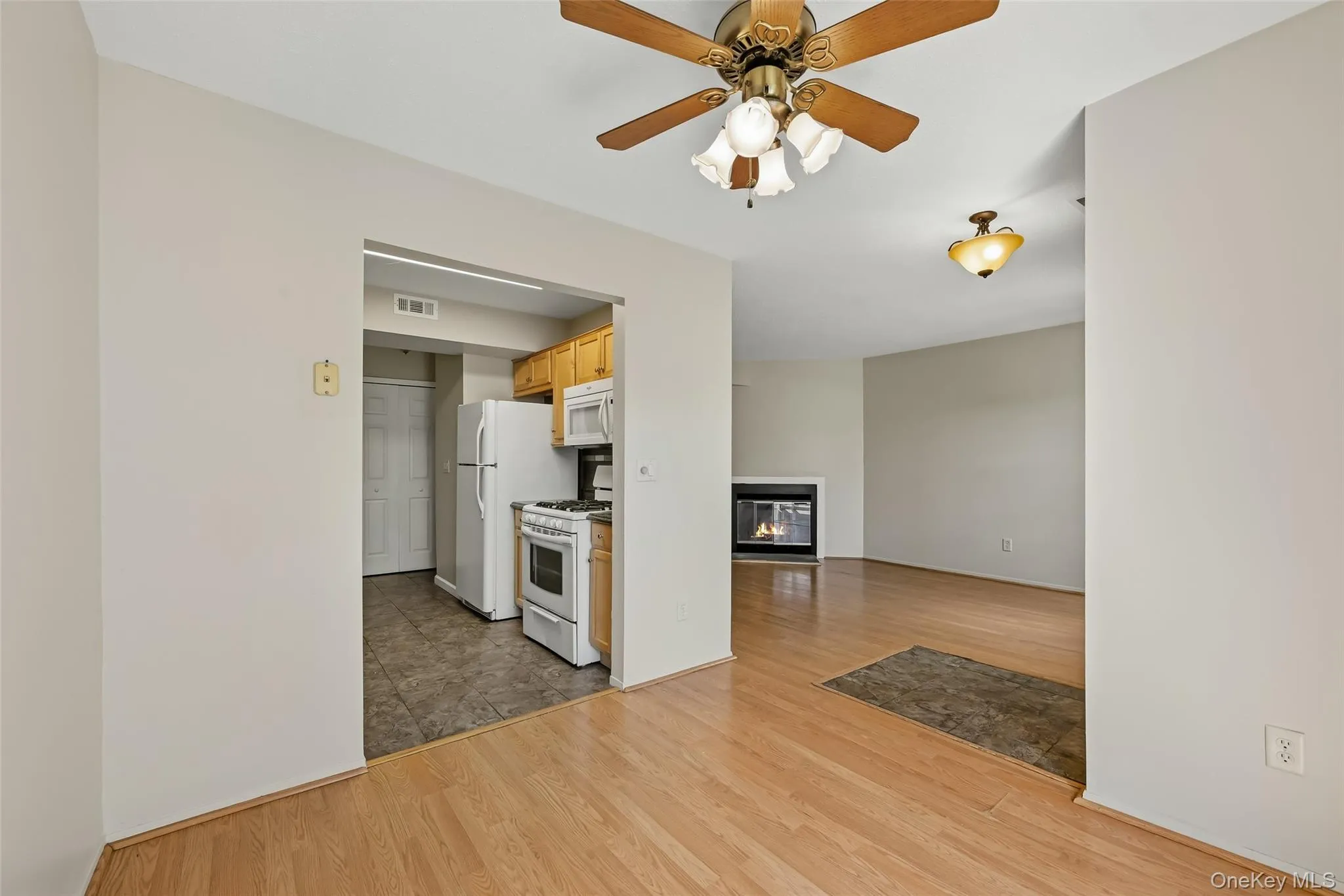 Wood-finish flooring throughout, with kitchen featuring wood cabinetry, and appliances Wood-finish flooring throughout, with kitchen featuring wood cabinetry, and appliances