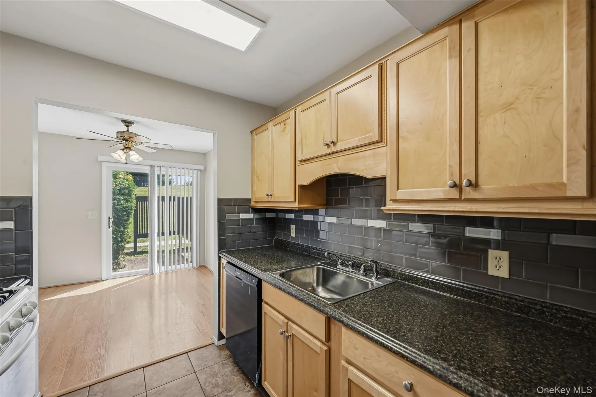 Wood-finish cabinetry, speckled countertops, and a subway tile backsplash define this kitchen Wood-finish cabinetry, speckled countertops, and a subway tile backsplash define this kitchen