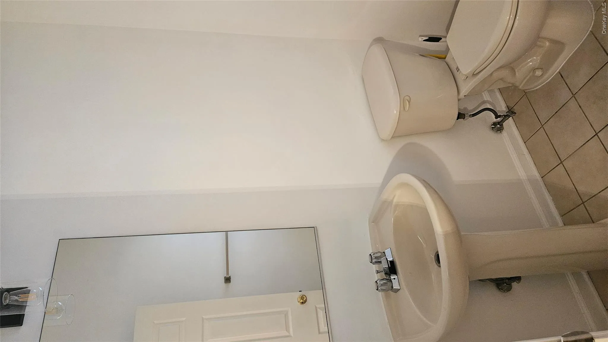 Powder room featuring toilet and tile patterned floors Powder room featuring toilet and tile patterned floors