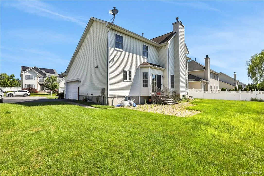 Rear view of house with a garage, lawn and patio. Rear view of house with a garage, lawn and patio.