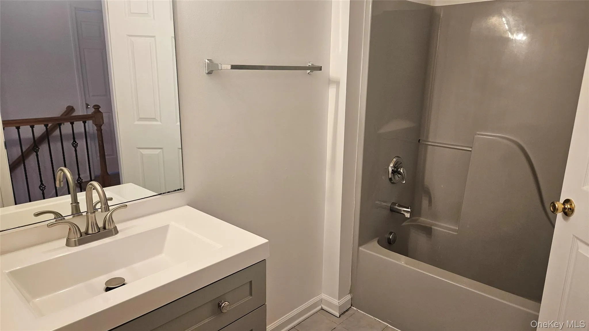 Upstairs hall Bathroom with bathing tub / shower combination, tile patterned floors, vanity, and baseboards Upstairs hall Bathroom with bathing tub / shower combination, tile patterned floors, vanity, and baseboards