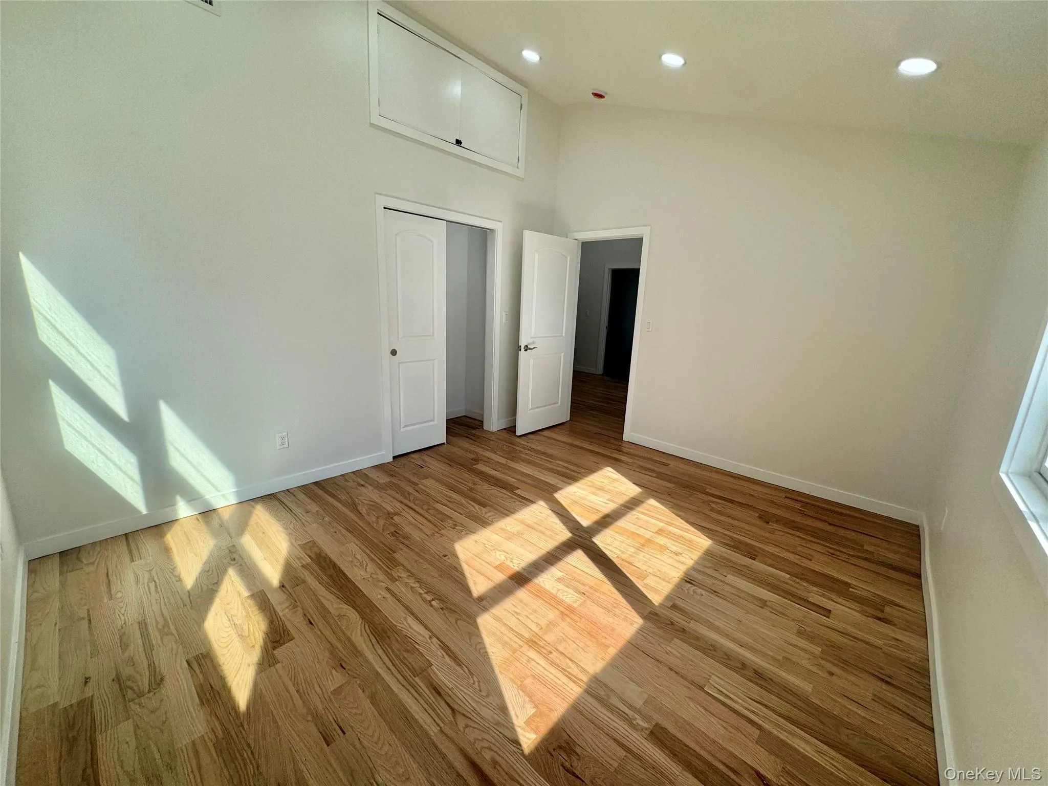 Bright, open room featuring hardwood flooring throughout, recessed ceiling lighting, and multiple windows allowing abundant natural light Bright, open room featuring hardwood flooring throughout, recessed ceiling lighting, and multiple windows allowing abundant natural light