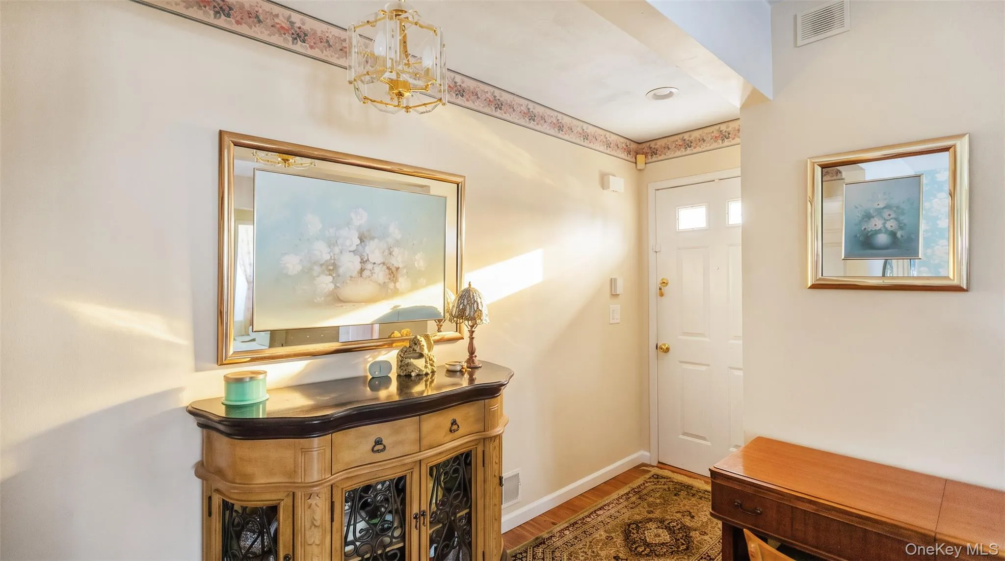Entryway featuring a white paneled door with glass inserts, overhead recessed lighting, and wood-finish flooring Entryway featuring a white paneled door with glass inserts, overhead recessed lighting, and wood-finish flooring