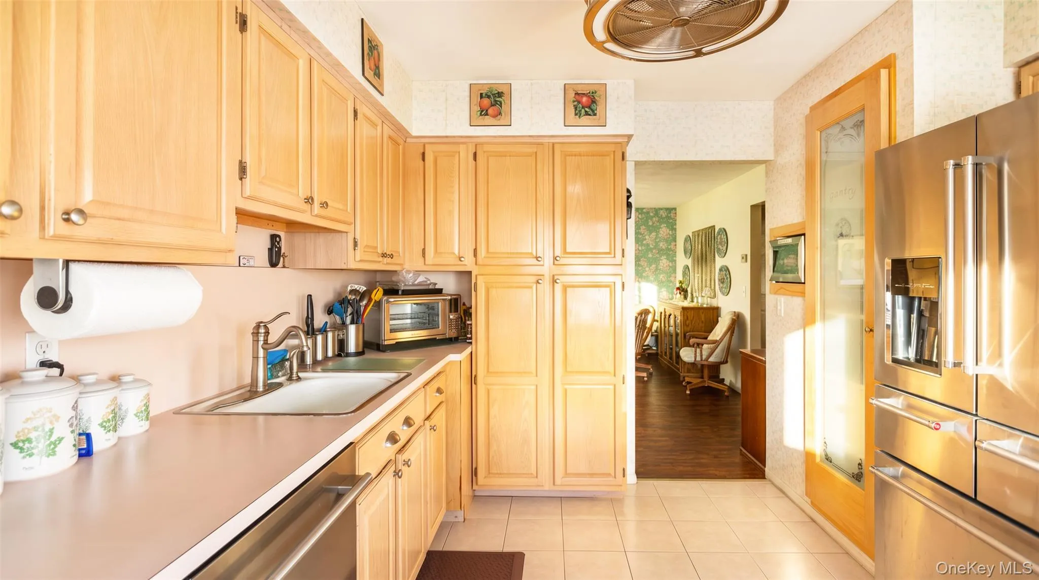 Light wood cabinetry, stainless steel appliances, tile flooring, frosted glass pantry, and built in wine fridge. Light wood cabinetry, stainless steel appliances, tile flooring, frosted glass pantry, and built in wine fridge.