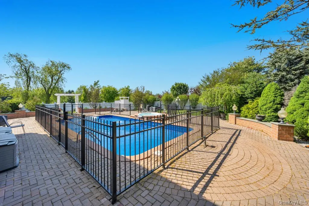 Expansive outdoor living area featuring a fenced swimming pool with an integrated spa Expansive outdoor living area featuring a fenced swimming pool with an integrated spa