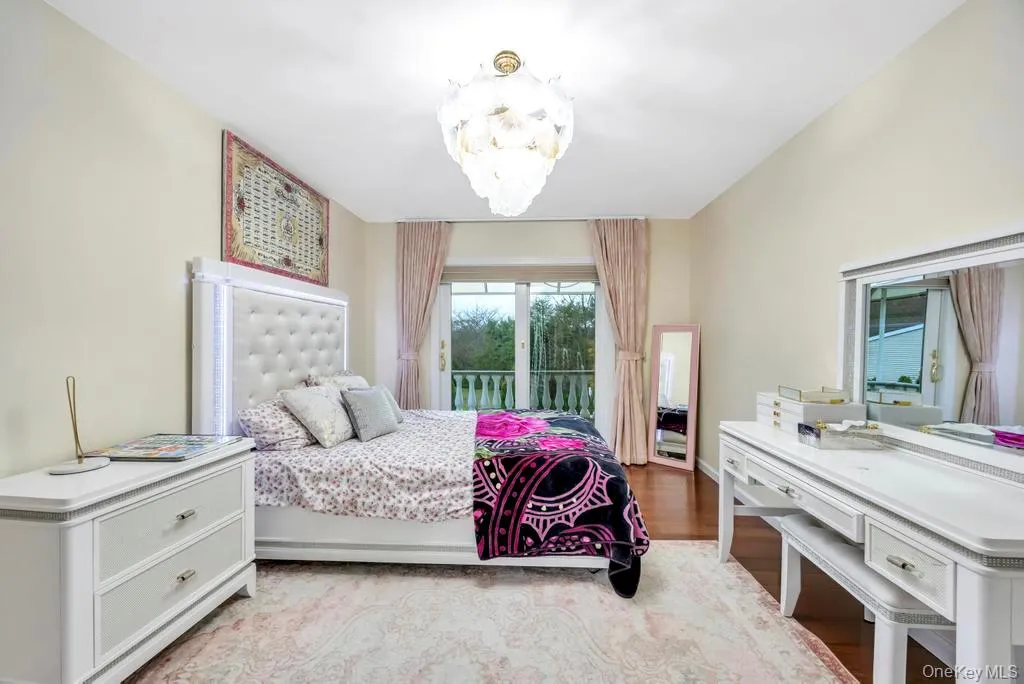 Bedroom with light wood-style flooring, access to outside, and a chandelier Bedroom with light wood-style flooring, access to outside, and a chandelier