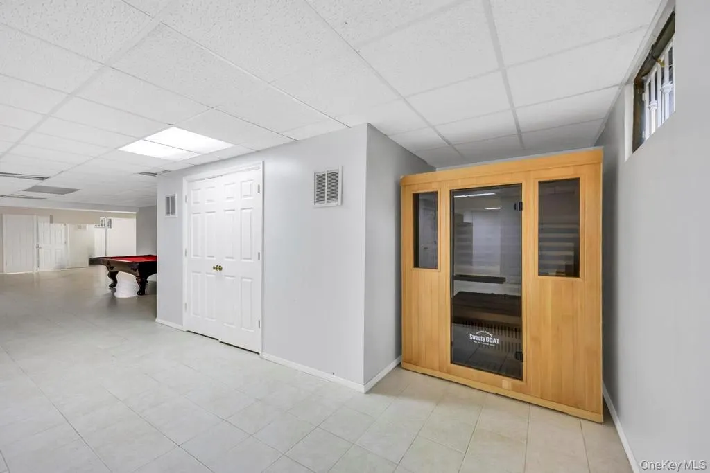Hall with a sauna, a paneled ceiling, and light tile patterned floors Hall with a sauna, a paneled ceiling, and light tile patterned floors