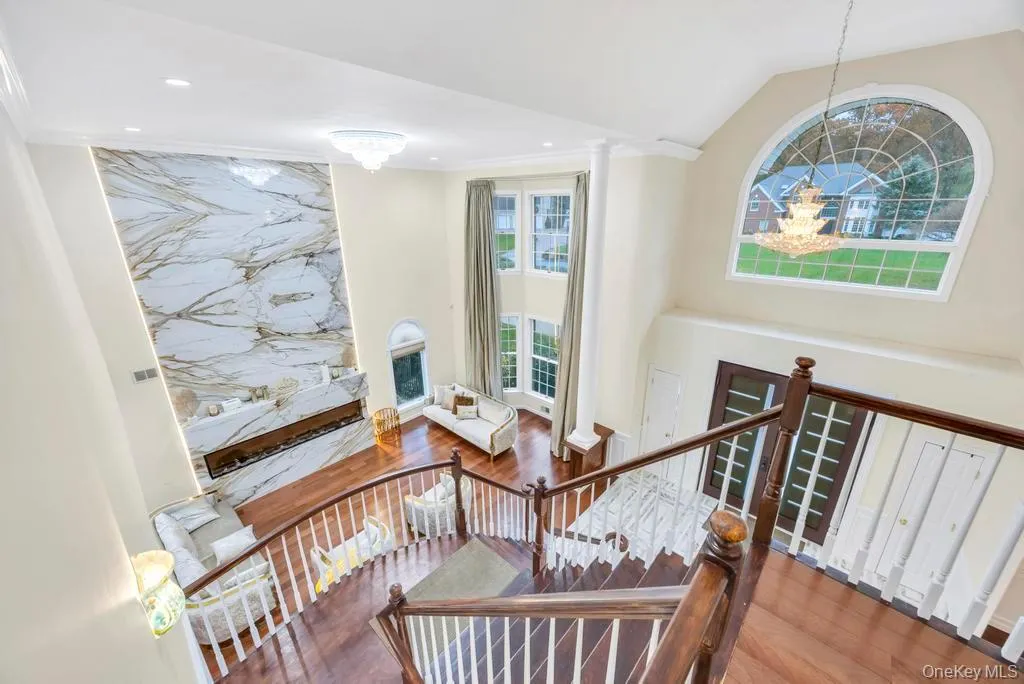 Staircase featuring a chandelier, wood finished floors, ornamental molding, recessed lighting, and lofted ceiling Staircase featuring a chandelier, wood finished floors, ornamental molding, recessed lighting, and lofted ceiling