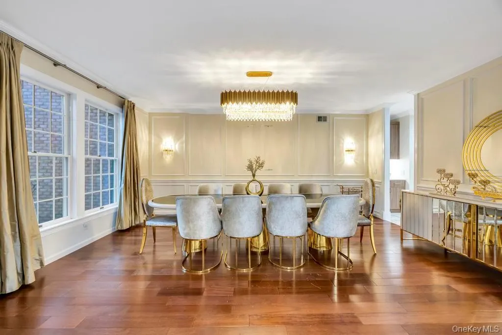 Dining room with a decorative wall, dark wood finished floors, and a chandelier Dining room with a decorative wall, dark wood finished floors, and a chandelier
