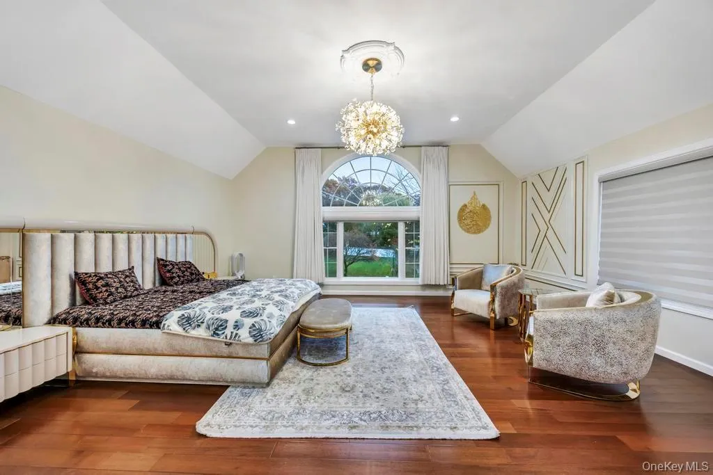 Bedroom featuring lofted ceiling, dark wood-type flooring, a chandelier, and recessed lighting Bedroom featuring lofted ceiling, dark wood-type flooring, a chandelier, and recessed lighting