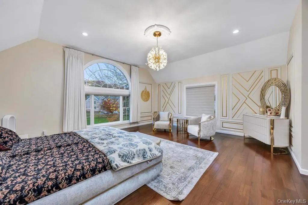 Bedroom with dark wood-style floors, lofted ceiling, a chandelier, and recessed lighting Bedroom with dark wood-style floors, lofted ceiling, a chandelier, and recessed lighting