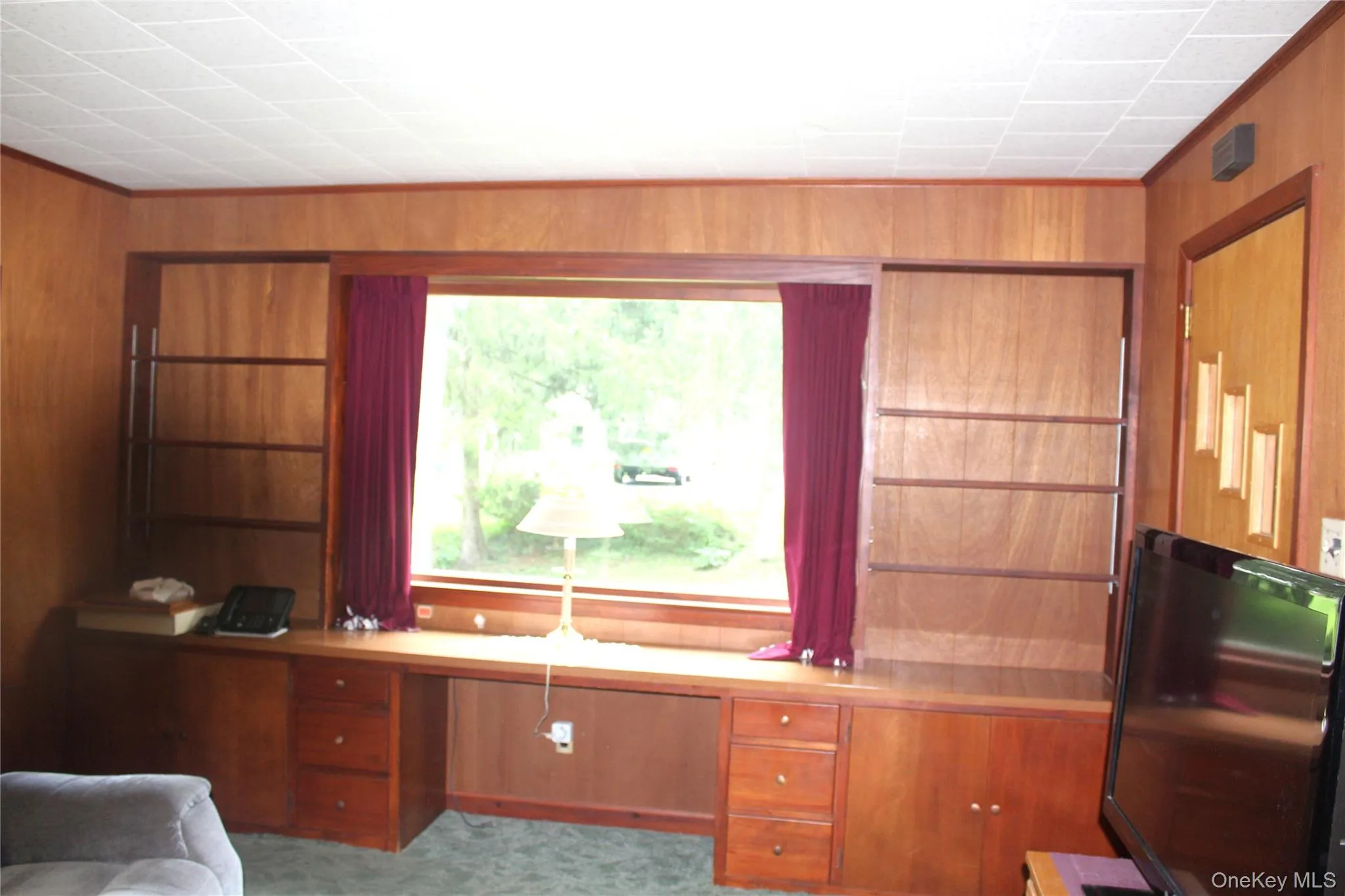 Built-in wood-finish desk with integrated shelving and drawer storage Built-in wood-finish desk with integrated shelving and drawer storage