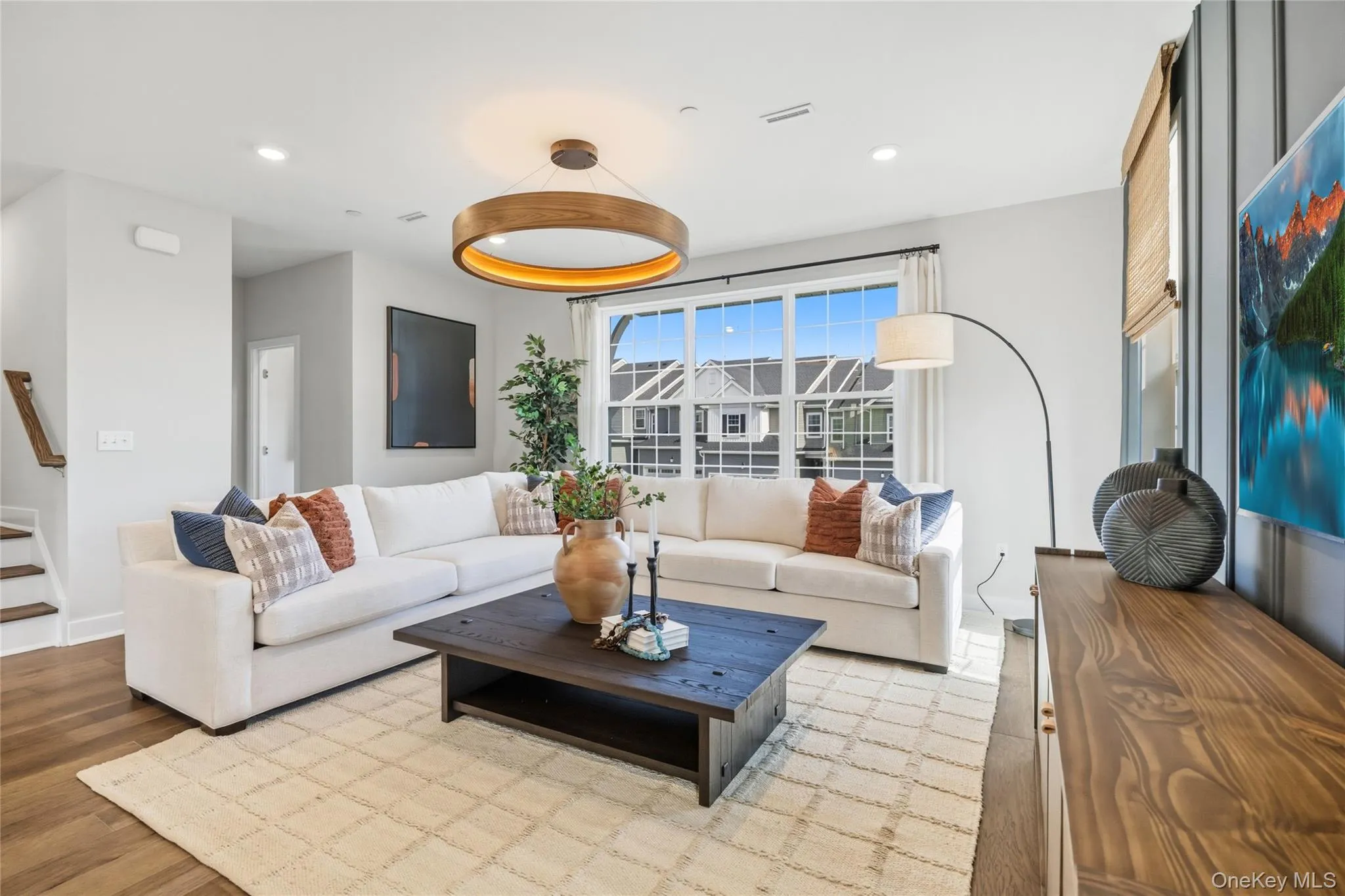 Spacious living area featuring large windows, wood-finish flooring and recessed lighting. Spacious living area featuring large windows, wood-finish flooring and recessed lighting.