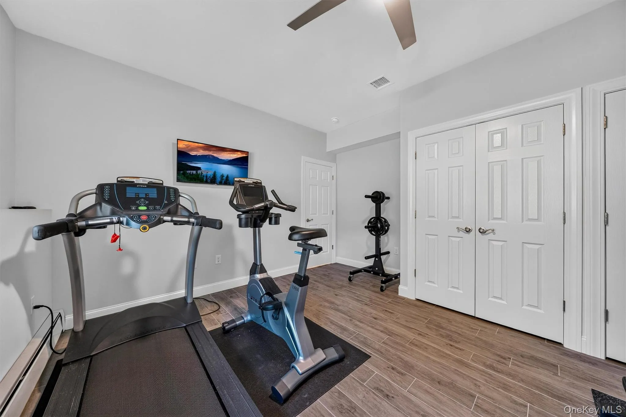 Wood-finish flooring, light gray wall paint, white trim, and white paneled doors Wood-finish flooring, light gray wall paint, white trim, and white paneled doors