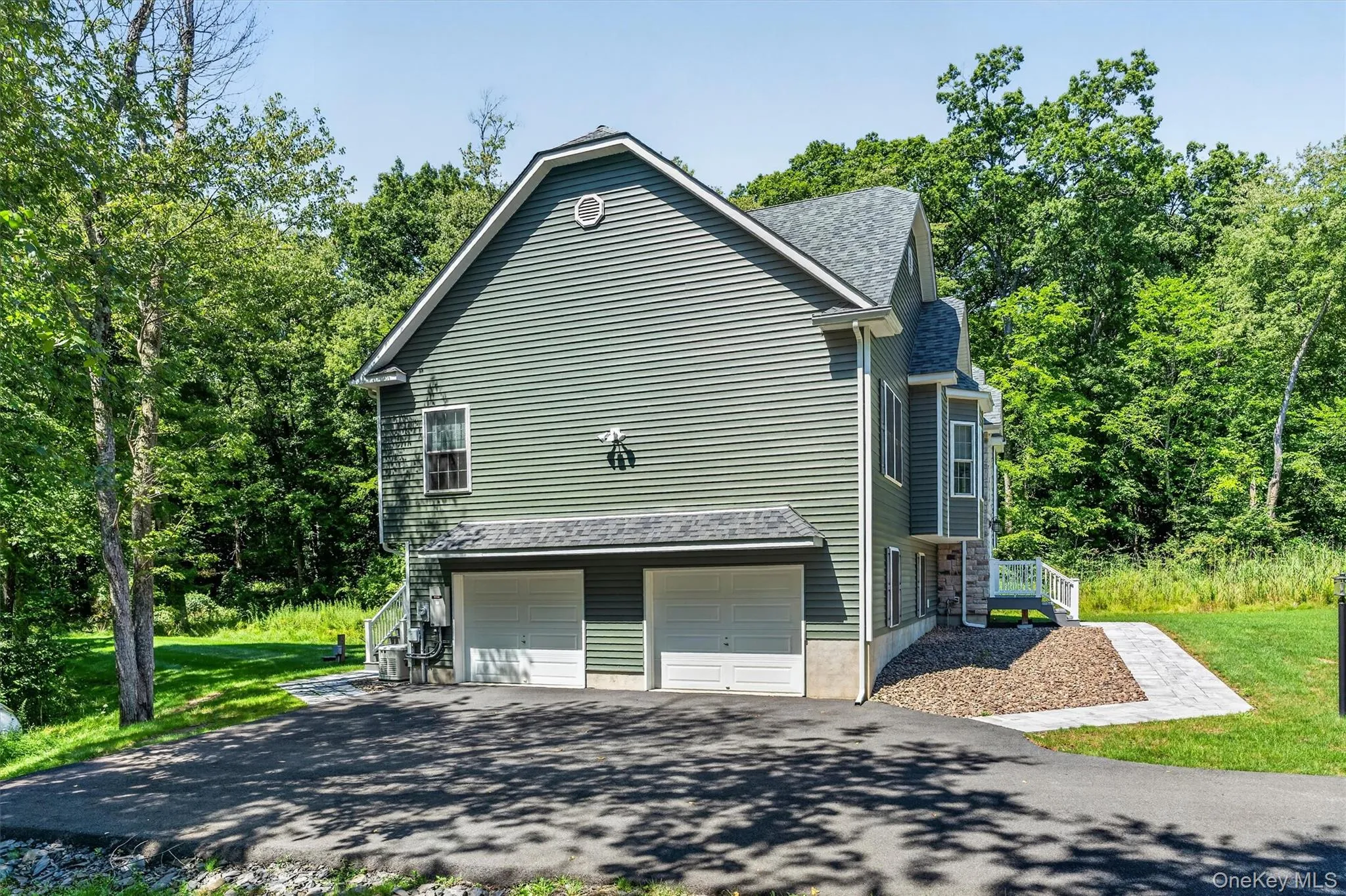 Two-car garage, durable siding exterior, stone facade accents, paved driveway, and established landscaping Two-car garage, durable siding exterior, stone facade accents, paved driveway, and established landscaping