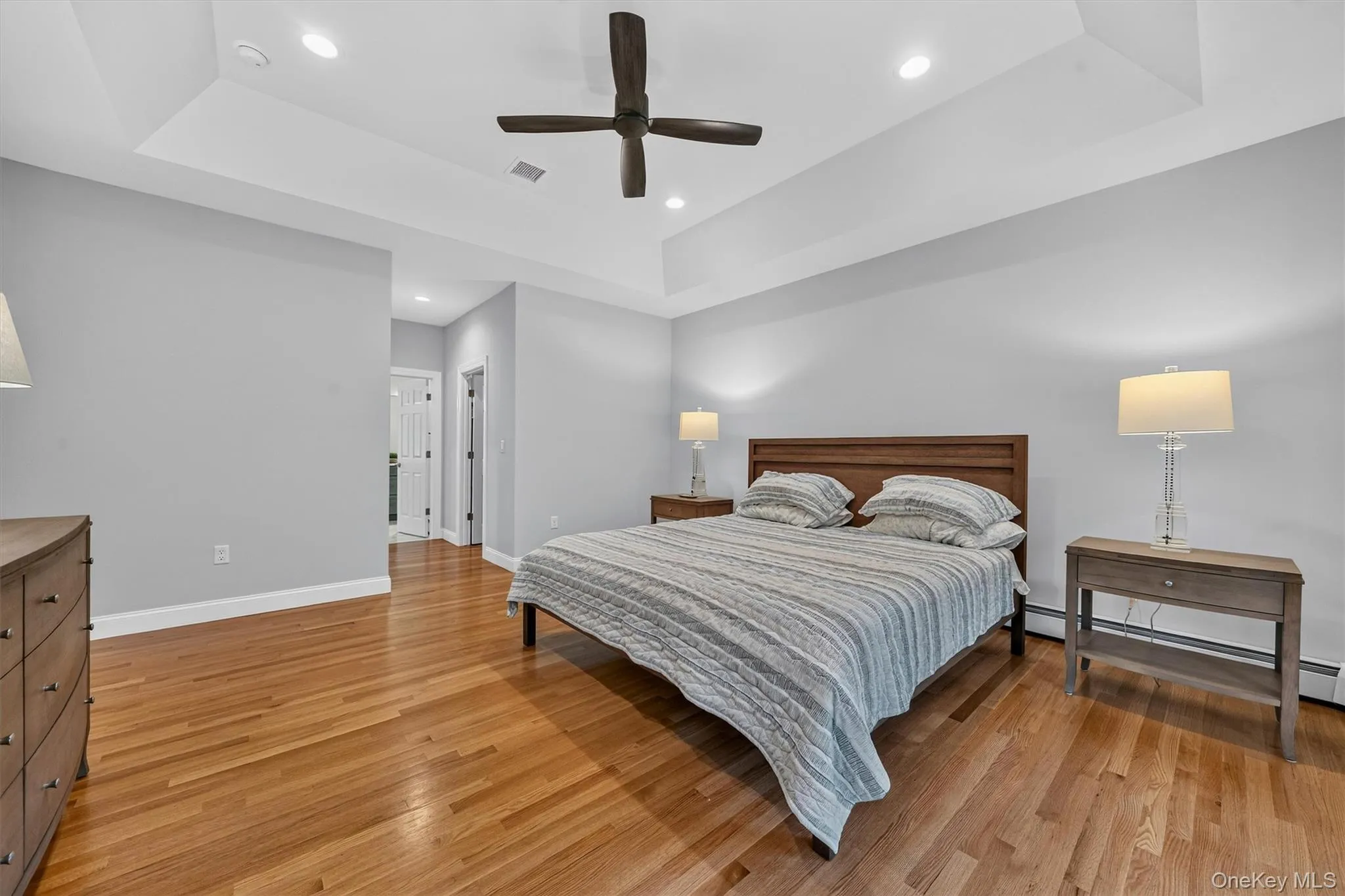 Hardwood flooring, tray ceiling, recessed lighting, and a ceiling fan Hardwood flooring, tray ceiling, recessed lighting, and a ceiling fan