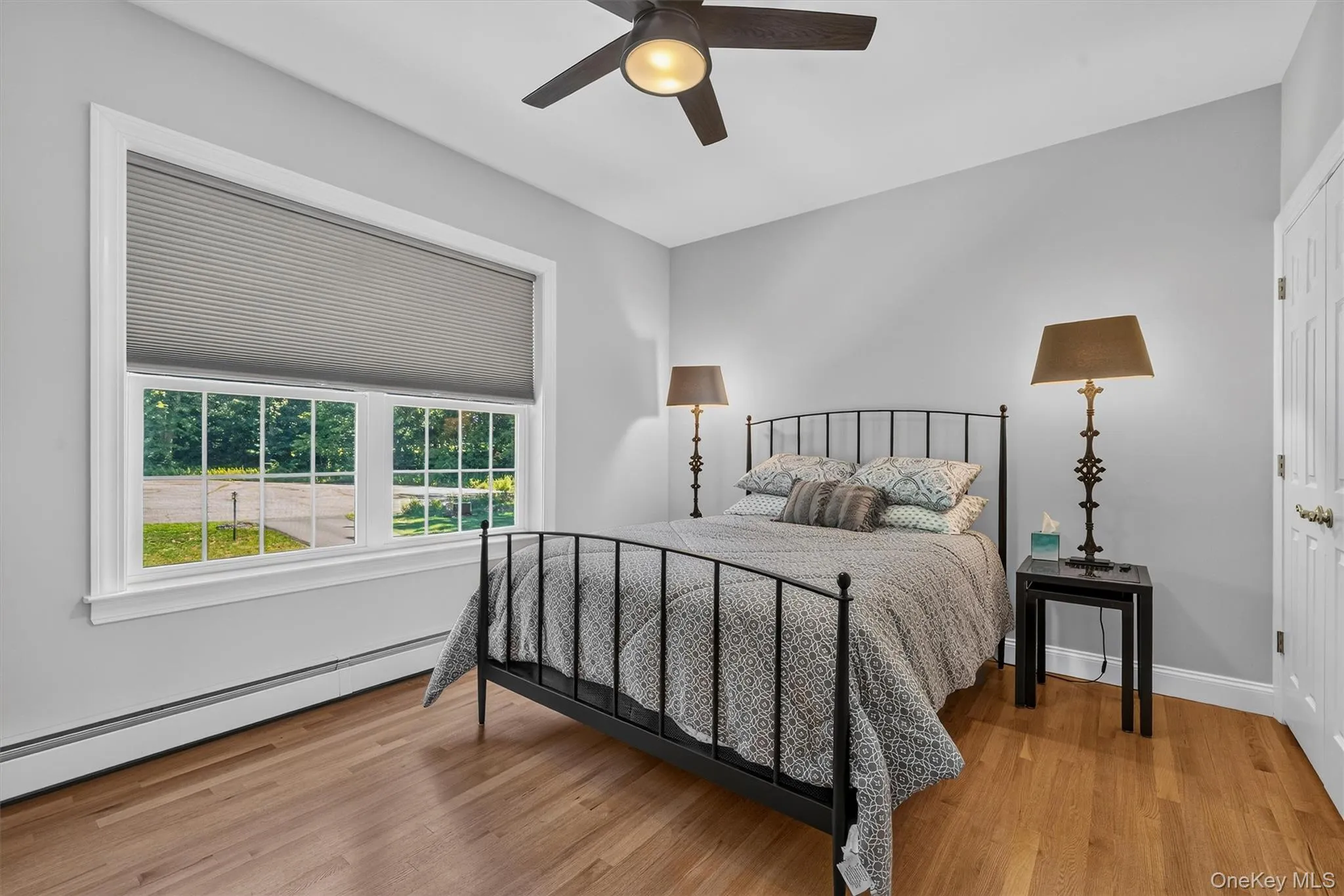 Hardwood flooring, painted walls, window with blinds, ceiling fan, and a paneled door Hardwood flooring, painted walls, window with blinds, ceiling fan, and a paneled door