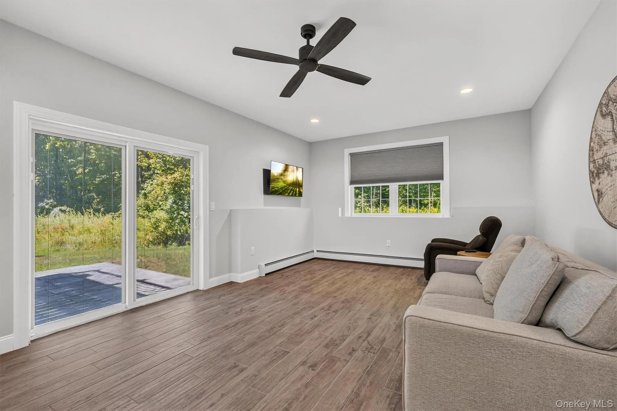 Wood-finish flooring, recessed lighting, and a dark-toned ceiling fan Wood-finish flooring, recessed lighting, and a dark-toned ceiling fan