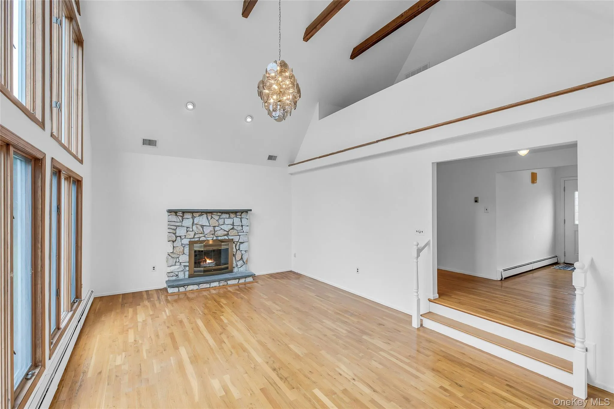 Sunken Livingroom with hardwood floors, vaulted ceiling and storage loft area Sunken Livingroom with hardwood floors, vaulted ceiling and storage loft area