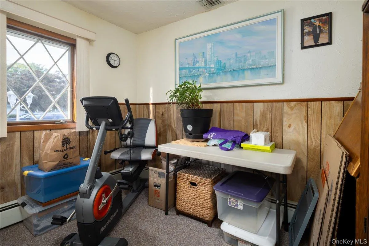 Diamond-pattern window, wood-paneled wall, wall-to-wall carpeting, and white painted walls Diamond-pattern window, wood-paneled wall, wall-to-wall carpeting, and white painted walls