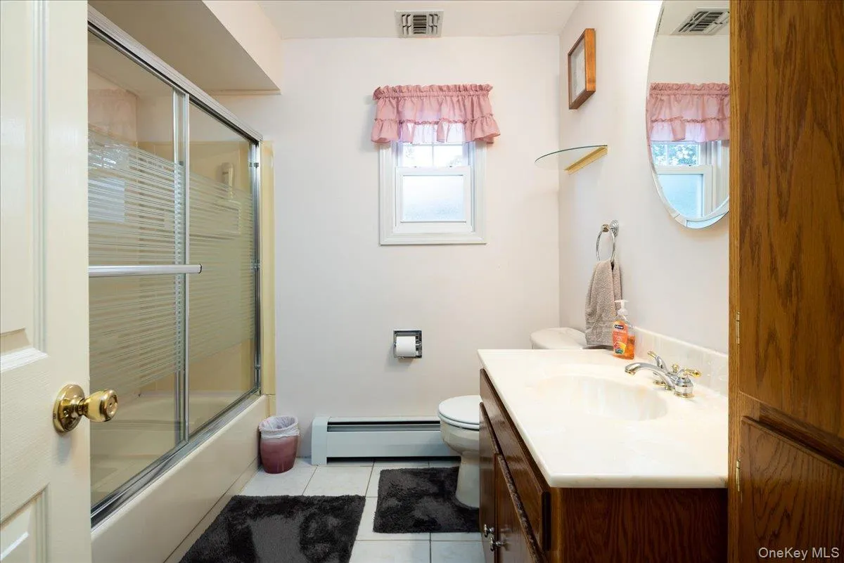 White tile flooring with a built-in bathtub and glass shower enclosure White tile flooring with a built-in bathtub and glass shower enclosure