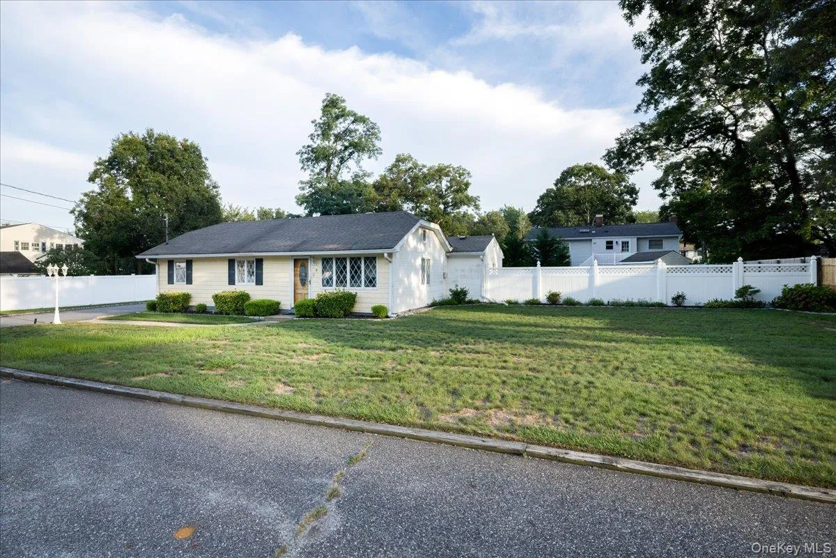 Ranch-style residence featuring light-toned siding, black shutters, and a dark shingle roof Ranch-style residence featuring light-toned siding, black shutters, and a dark shingle roof