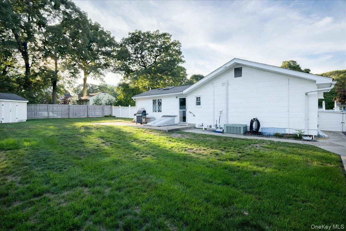 Expansive grassy yard with a white vinyl fence and a second wooden fence Expansive grassy yard with a white vinyl fence and a second wooden fence