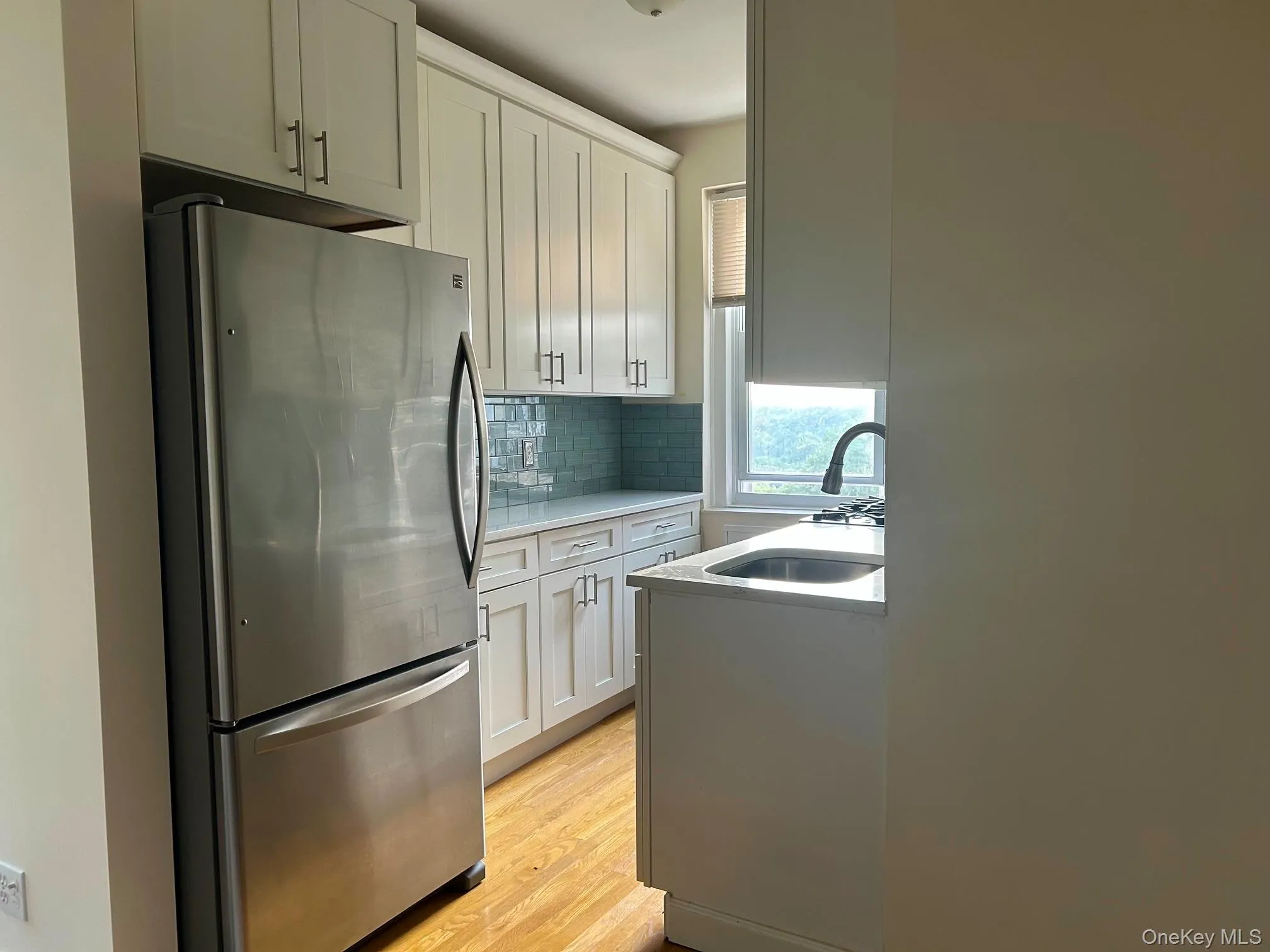 Sleek and on newer side. Dishwasher, Microwave, hardwood floor and green backsplash. Faces East. Sleek and on newer side. Dishwasher, Microwave, hardwood floor and green backsplash. Faces East.
