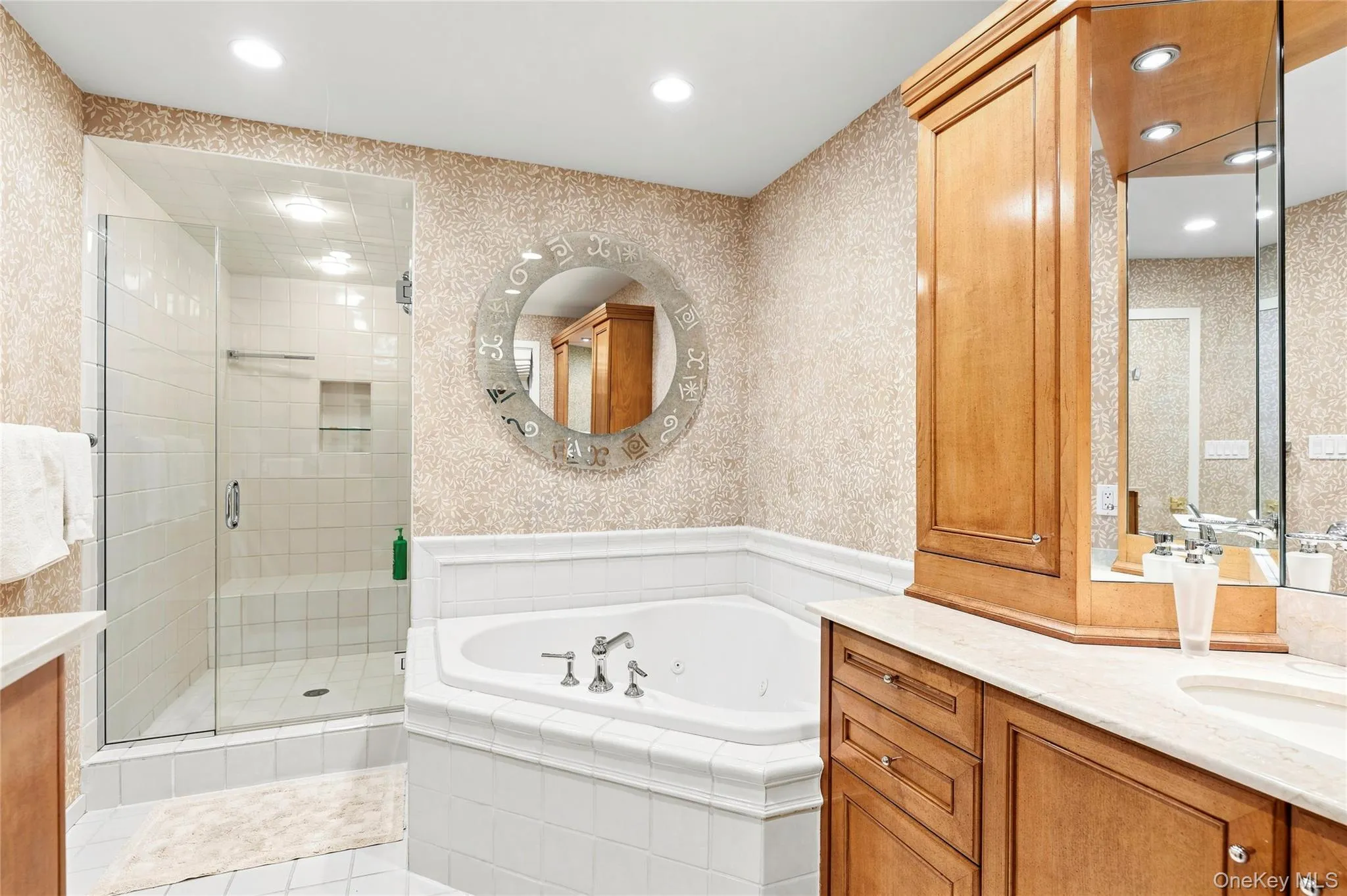 Primary bathroom with spa tub, shower and mirrored vanity Primary bathroom with spa tub, shower and mirrored vanity