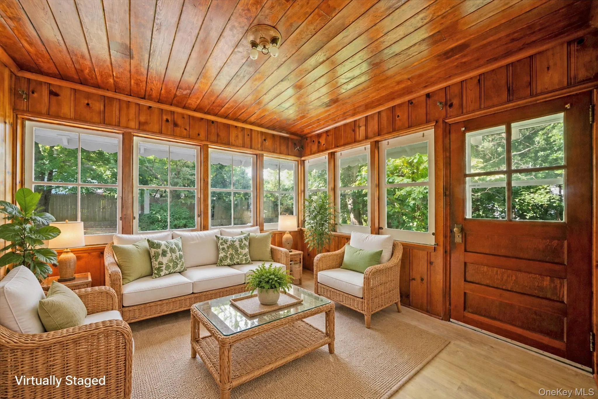 Wood-paneled walls and ceiling, multiple large windows, and a paneled entry door with glass inserts Wood-paneled walls and ceiling, multiple large windows, and a paneled entry door with glass inserts