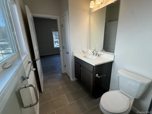 Bathroom featuring vanity, tile patterned floors, and toilet Bathroom featuring vanity, tile patterned floors, and toilet