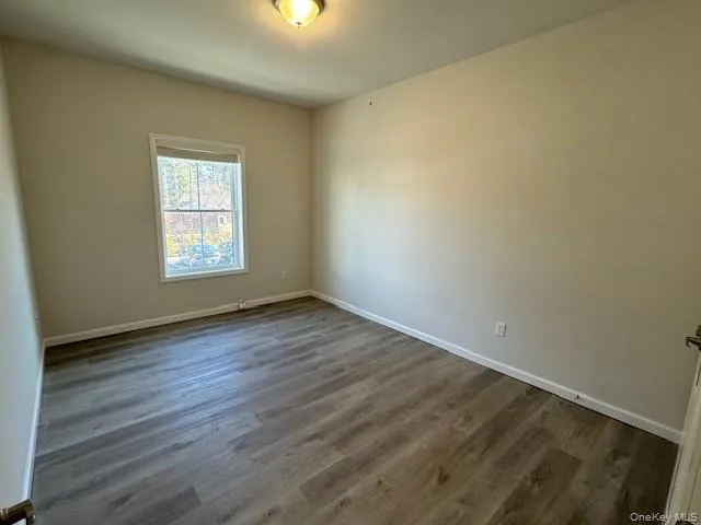Spare room featuring dark hardwood / wood-style floors Spare room featuring dark hardwood / wood-style floors