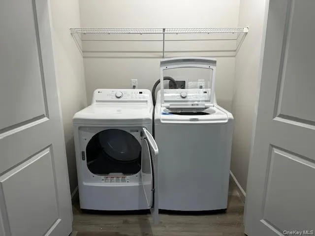 Washroom featuring dark wood-type flooring and washer and clothes dryer Washroom featuring dark wood-type flooring and washer and clothes dryer