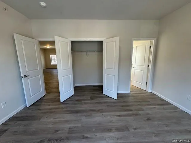 Unfurnished bedroom featuring dark hardwood / wood-style flooring and a closet Unfurnished bedroom featuring dark hardwood / wood-style flooring and a closet