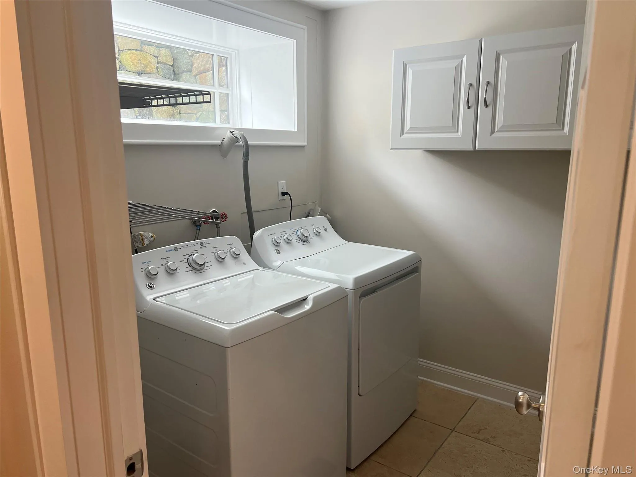 Laundry room with shelves and a lot of storage on opposite wall Laundry room with shelves and a lot of storage on opposite wall