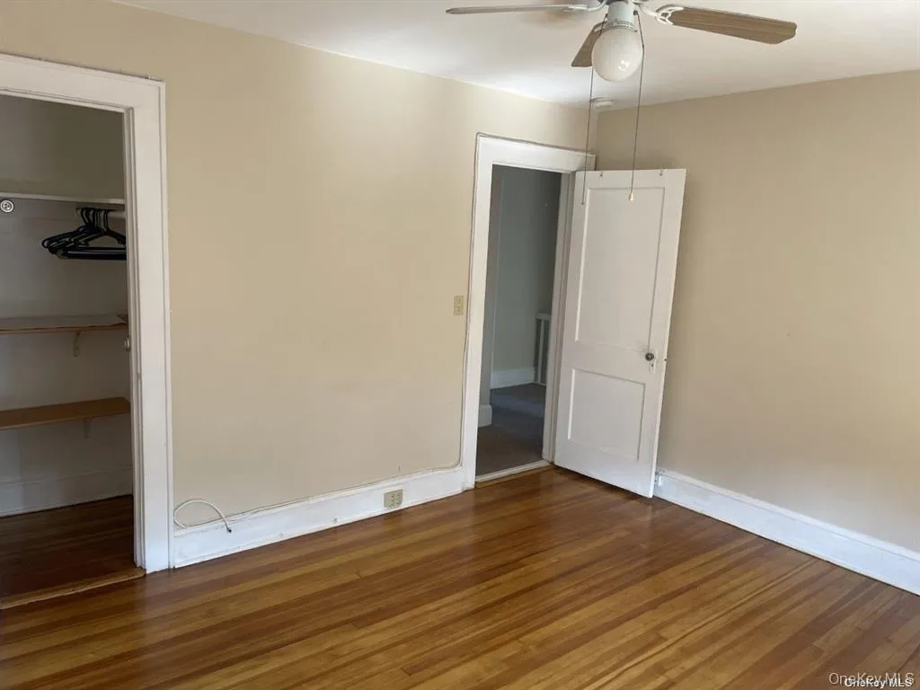 Hardwood flooring throughout, ceiling fan with light fixture, and closet with built-in shelving Hardwood flooring throughout, ceiling fan with light fixture, and closet with built-in shelving