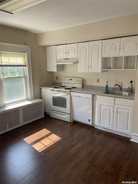 Kitchen featuring white cabinetry, a white electric range, a white dishwasher, wood-finish flooring, and a single-basin sink Kitchen featuring white cabinetry, a white electric range, a white dishwasher, wood-finish flooring, and a single-basin sink