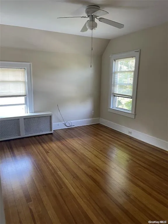 Hardwood flooring, painted walls, ceiling fan with light fixture, and two windows and large closet Hardwood flooring, painted walls, ceiling fan with light fixture, and two windows and large closet