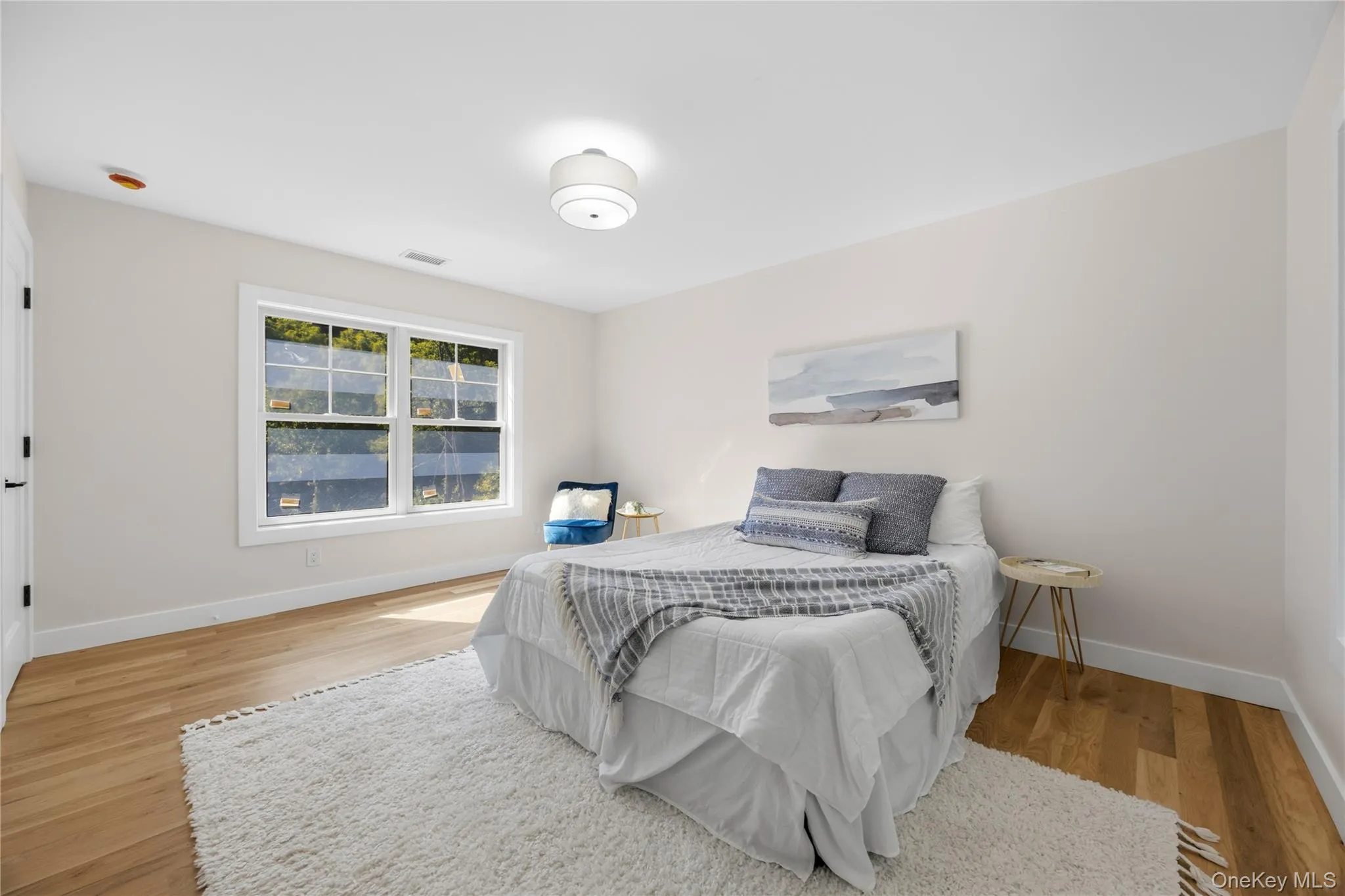 Light wood-finish flooring, white walls, and a multi-pane window with white trim Light wood-finish flooring, white walls, and a multi-pane window with white trim