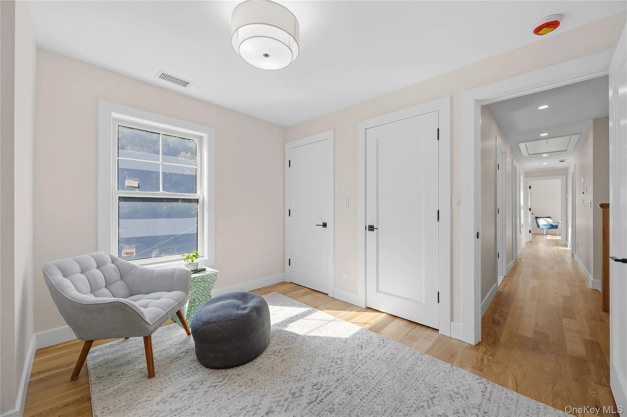 Hardwood flooring throughout, white trim, and a contemporary ceiling light fixture Hardwood flooring throughout, white trim, and a contemporary ceiling light fixture