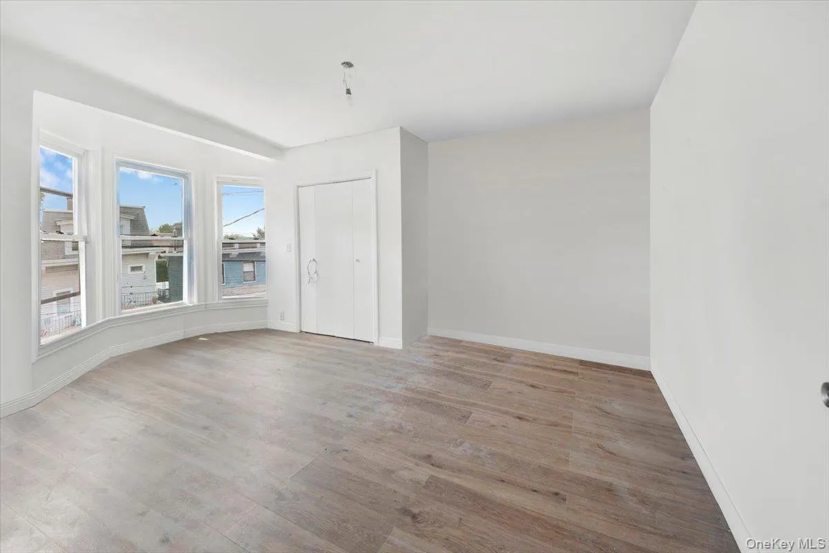 Unfurnished room with wood finished floors and baseboards Unfurnished room with wood finished floors and baseboards