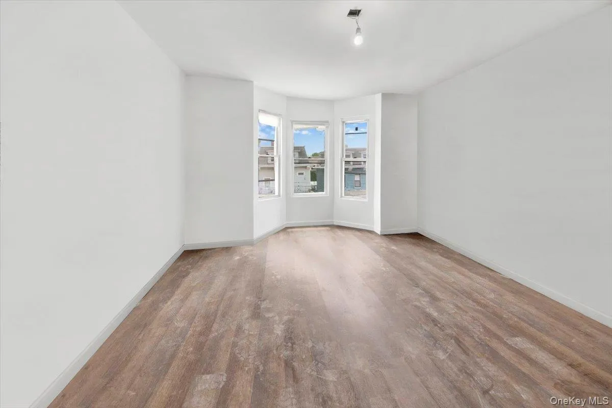 Spare room with wood finished floors and baseboards Spare room with wood finished floors and baseboards