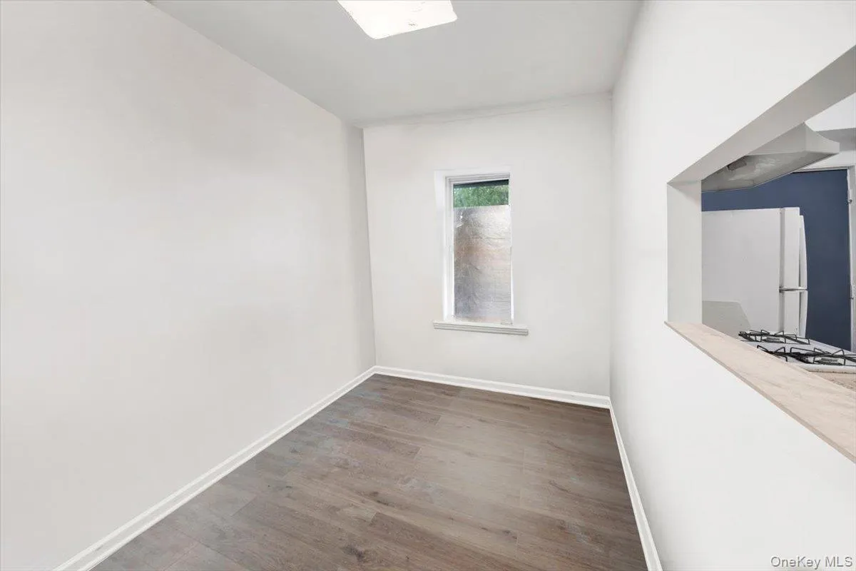 Unfurnished room with wood finished floors and baseboards Unfurnished room with wood finished floors and baseboards