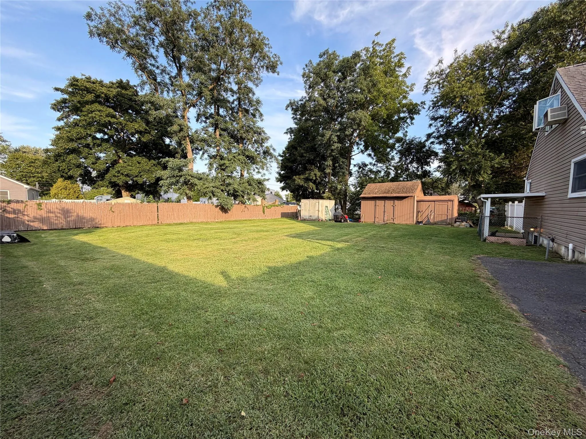 oversized rear yard with mature trees, a wood privacy fence, and two storage sheds oversized rear yard with mature trees, a wood privacy fence, and two storage sheds
