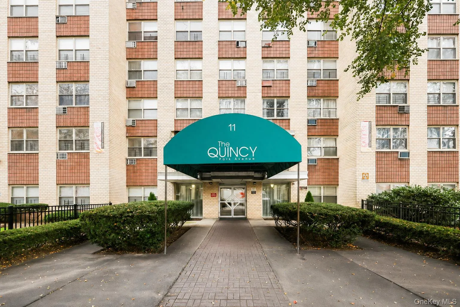 Welcome to the Quincy Multi-story brick facade building Welcome to the Quincy Multi-story brick facade building