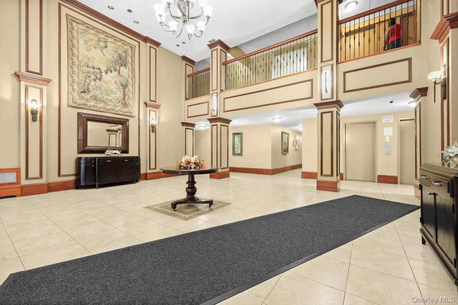 Welcoming Lobby with tile flooring, chandelier lighting, and decorative wall paneling with wood trim Welcoming Lobby with tile flooring, chandelier lighting, and decorative wall paneling with wood trim