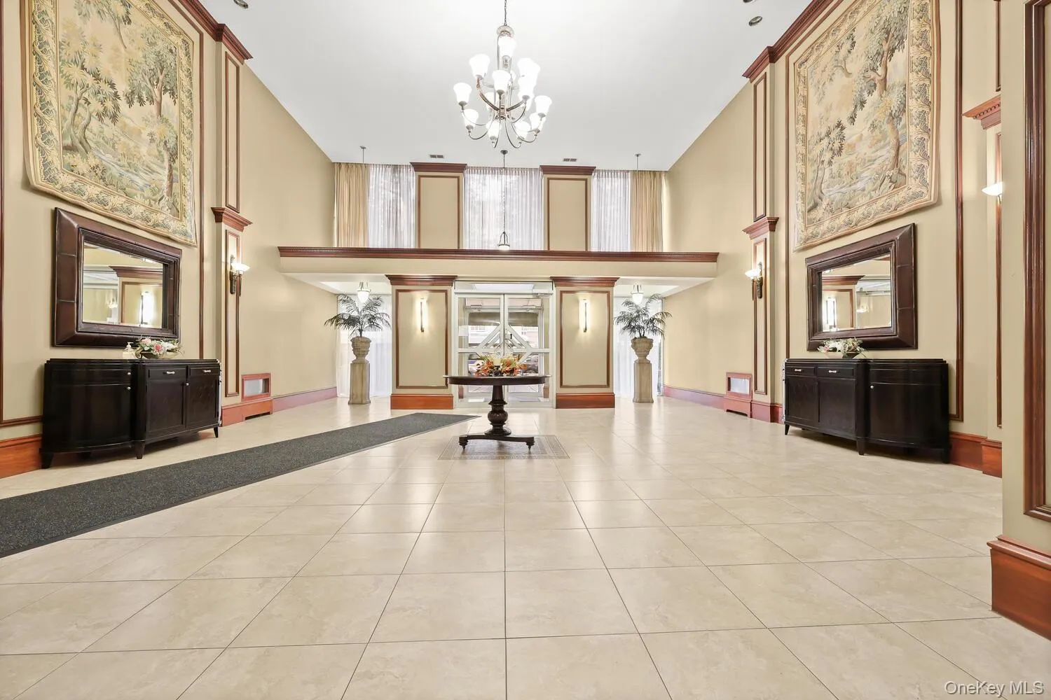 Welcoming Lobby with tile flooring, chandelier lighting, and decorative wall paneling with wood trim Welcoming Lobby with tile flooring, chandelier lighting, and decorative wall paneling with wood trim