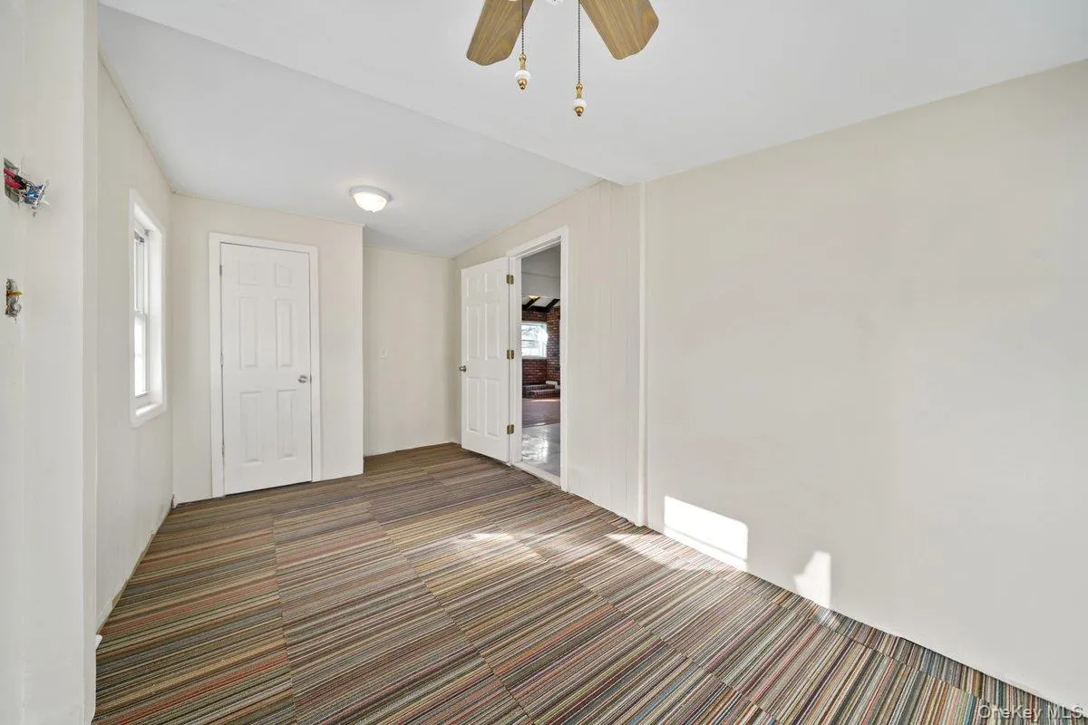 Unfurnished bedroom featuring multiple windows, carpet floors, and a ceiling fan Unfurnished bedroom featuring multiple windows, carpet floors, and a ceiling fan