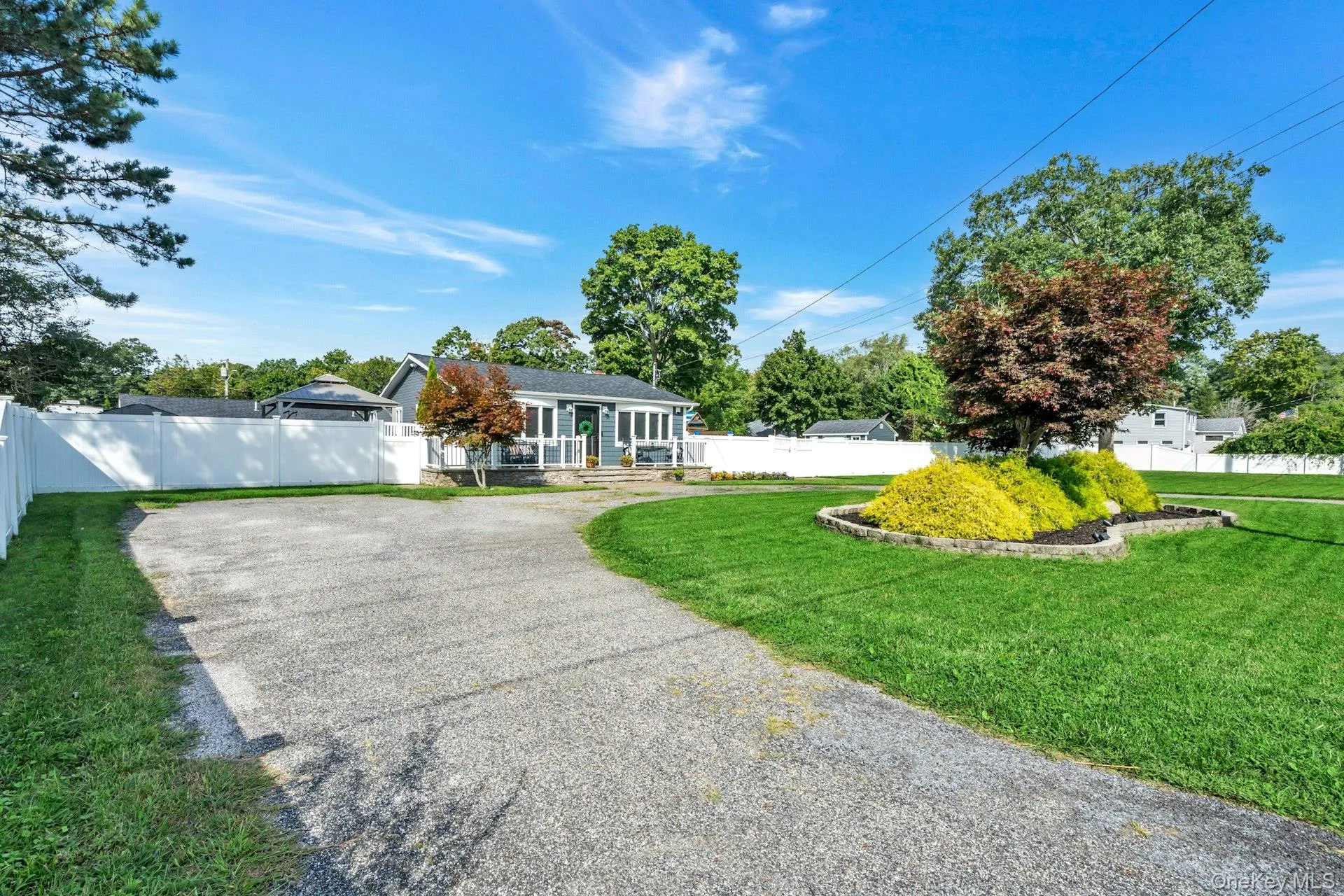 Front of the home with large circular driveway and fully fenced yard Front of the home with large circular driveway and fully fenced yard