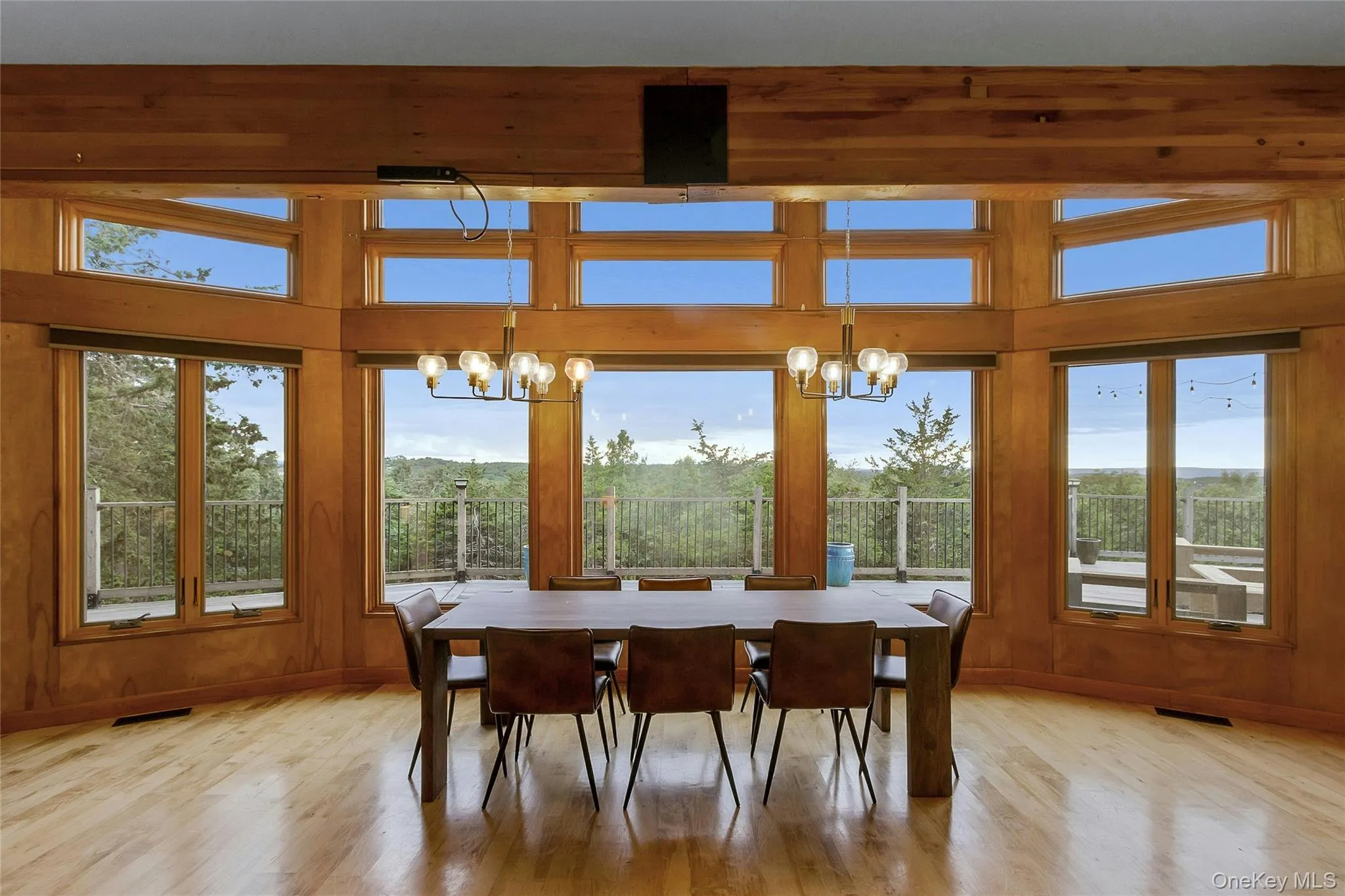 Hardwood flooring, wood-paneled walls, exposed wood beams, and a chandelier lighting fixture Hardwood flooring, wood-paneled walls, exposed wood beams, and a chandelier lighting fixture